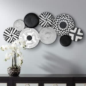 handcrafted abstract metal wall art featuring white and black discs with multi-pattern designs.